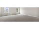 Spacious carpeted bedroom with two sunny windows, and neutral walls at 104 Pisgah St, Sanford, NC 27330