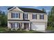 Charming two-story home featuring stone accents, a two-car garage, and manicured landscaping at 104 Pisgah St, Sanford, NC 27330