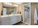 A modern bathroom with double vanity sinks, white cabinets, and a walk-in closet at 104 Siebold St, Garner, NC 27529