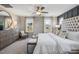 Bedroom featuring a large upholstered headboard, ceiling fan, and two windows with backyard views at 104 Siebold St, Garner, NC 27529