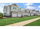 Row of newly-constructed townhomes featuring attached garages and professionally manicured landscaping at 104 Siebold St, Garner, NC 27529