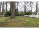 Spacious backyard featuring lush greenery, mature trees, and a white picket fence at 105 John St, Louisburg, NC 27549