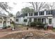 Spacious backyard featuring a brick patio, lush landscaping, and a charming two-story white home at 105 John St, Louisburg, NC 27549