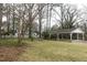 Expansive backyard with lush lawn, mature trees, and a carport at 105 John St, Louisburg, NC 27549