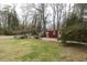 Spacious backyard featuring a red shed and a charming outdoor sitting area, perfect for relaxing and entertaining at 105 John St, Louisburg, NC 27549