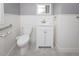 Neutral bathroom with white vanity, white wainscoting, and accessible features at 105 John St, Louisburg, NC 27549