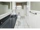 Clean and classic bathroom with white tile floors, white cabinets, and a black countertop at 105 John St, Louisburg, NC 27549