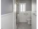 Bright bathroom featuring a walk-in shower, neutral tile, grab bars, and white wainscoting at 105 John St, Louisburg, NC 27549