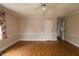 Neutral bedroom featuring natural light, ceiling fan, and hardwood floors at 105 John St, Louisburg, NC 27549