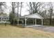 Spacious open carport featuring ceiling fans and concrete flooring, set amidst a lush green landscape at 105 John St, Louisburg, NC 27549