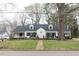 Charming two-story home with dormer windows, black shutters, brick walkway and mature landscaping at 105 John St, Louisburg, NC 27549