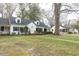 Charming two-story home with dormer windows, black shutters, brick walkway and mature landscaping at 105 John St, Louisburg, NC 27549
