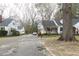 Long driveway leading to a charming home with a brick walkway and mature landscaping at 105 John St, Louisburg, NC 27549