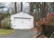 White garage with double doors, set beside a brick-columned fence at 105 John St, Louisburg, NC 27549