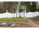 Beautiful garden path leading through a white trellis archway, accented with lush greenery and flowering plants at 105 John St, Louisburg, NC 27549
