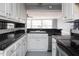 Cozy kitchen showcasing white cabinets, black countertops, and a stainless steel sink, designed for efficiency and style at 105 John St, Louisburg, NC 27549