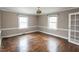 Inviting living room with hardwood floors, neutral walls, and large windows that brings in natural light at 105 John St, Louisburg, NC 27549