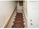 Carpeted stairway with wood railing leading to the upper level of the home at 105 John St, Louisburg, NC 27549