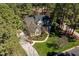 Stunning aerial view of a traditional home with lush landscaping and a winding driveway nestled among mature trees at 1321 Colonial Club Rd, Wake Forest, NC 27587
