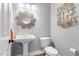 Charming powder room with pedestal sink, toilet, and decorative mirror at 1321 Colonial Club Rd, Wake Forest, NC 27587