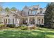 Charming two-story home boasts a manicured lawn and inviting front porch with detailed trim work at 1321 Colonial Club Rd, Wake Forest, NC 27587