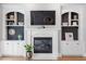 Fireplace with white mantle and flanking built-in shelving, cabinets, and a mounted television at 1321 Colonial Club Rd, Wake Forest, NC 27587
