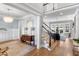 Bright foyer featuring hardwood floors, elegant staircase, and an open view to the living area at 1321 Colonial Club Rd, Wake Forest, NC 27587