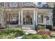 Inviting front porch with decorative pillars, hanging swing, and meticulously landscaped surroundings at 1321 Colonial Club Rd, Wake Forest, NC 27587