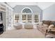 Spacious living room with built-in shelving, large windows, and neutral carpet flooring at 1321 Colonial Club Rd, Wake Forest, NC 27587