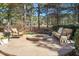 Cozy outdoor seating area around a circular stone fire pit on a paved patio, perfect for gatherings at 1321 Colonial Club Rd, Wake Forest, NC 27587