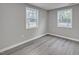 Bedroom featuring gray walls, wood-look flooring, and two windows for lots of natural light at 1323 Colon Rd, Sanford, NC 27330
