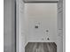 Open closet featuring gray walls, wood-look flooring, and utility connections at 1323 Colon Rd, Sanford, NC 27330