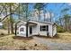 Exterior home view displays fresh landscaping, gravel driveway, and covered front porch at 1323 Colon Rd, Sanford, NC 27330