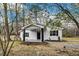 Quaint exterior showcasing a covered front porch, tidy landscaping, and a gravel walkway at 1323 Colon Rd, Sanford, NC 27330