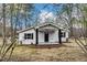 Charming home surrounded by trees and green grass with a covered front porch and a black door at 1323 Colon Rd, Sanford, NC 27330