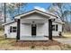 Inviting home featuring a covered front porch with black posts and black front door at 1323 Colon Rd, Sanford, NC 27330