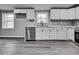Bright kitchen featuring white cabinets, stainless steel appliances, and gray wood-look flooring at 1323 Colon Rd, Sanford, NC 27330