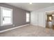 Bedroom with gray accent wall, neutral carpet, and view into the kitchen at 1573 Piney Falls Dr, Wendell, NC 27591