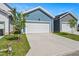 Detached blue garage with white door, a concrete driveway, and a young tree at 1573 Piney Falls Dr, Wendell, NC 27591
