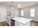 Bright kitchen with a center island, white cabinets, and stainless steel dishwasher at 1573 Piney Falls Dr, Wendell, NC 27591