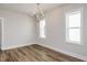 Open living room with wood-look flooring, a modern chandelier, and bright, natural light at 1573 Piney Falls Dr, Wendell, NC 27591