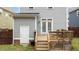 Back of home with wooden deck and steps leading to a partially grass backyard and gray siding at 215 Seventh St, Wake Forest, NC 27587