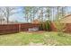Fenced backyard featuring a wood chip garden area with bench seating and green grass at 215 Seventh St, Wake Forest, NC 27587