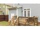 Wooden deck with railing, outdoor furniture and steps leading to a partially grass backyard at 215 Seventh St, Wake Forest, NC 27587