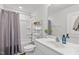 Well-lit bathroom featuring a vanity, toilet, and shower/tub combo with gray shower curtain at 215 Seventh St, Wake Forest, NC 27587