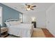 Bright bedroom featuring a ceiling fan, a serene blue accent wall, and two entry doors at 215 Seventh St, Wake Forest, NC 27587