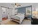 Well-lit bedroom with two windows, barn door to bathroom, neutral carpet and blue accent wall at 215 Seventh St, Wake Forest, NC 27587