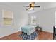 Neutral bedroom with a single bed, side table, ceiling fan, and two windows for lots of natural light at 215 Seventh St, Wake Forest, NC 27587