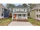 Charming home exterior with a welcoming front porch, brick accents, and neat landscaping at 215 Seventh St, Wake Forest, NC 27587