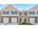 Inviting townhouse exteriors featuring stone accents, individual garages and neat landscaping at 279 Canopy Dr, Graham, NC 27253
